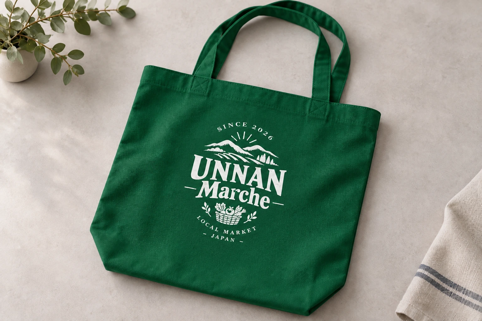 グリーンの帆布トートに白で印刷したUNNAN Marcheのロゴ